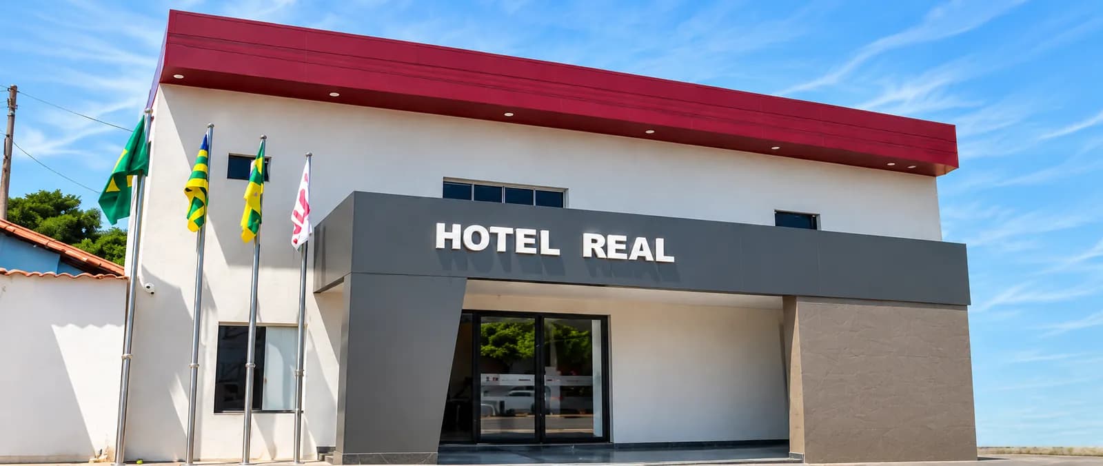 Fachada do Hotel Real, com o letreiro e as bandeiras na entrada